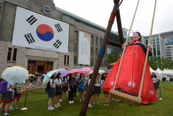 단오를 하루 앞둔 12일 오후 서울 광장을 찾은 학생들이 단오를 위해 설치된 대형 그네를 타며 즐거운 시간을 보내고 있다.  도준석 pado@seoul.co.kr