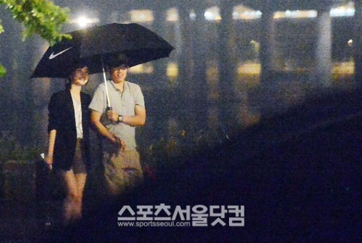 축구 스타 박지성과 SBS 김민지 아나운서가 18일 밤 한강시민공원에서 빗속 데이트를 즐기고 있다.<br>임영무·이새롬 기자