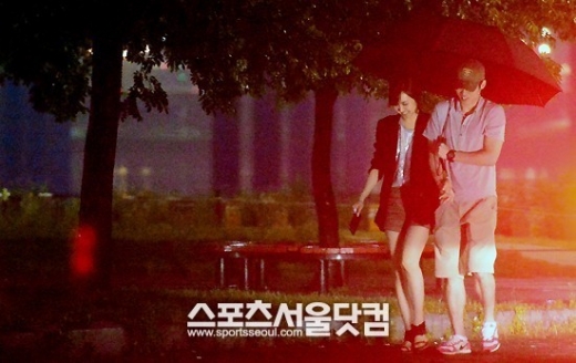 박지성과 김민지가 팔짱을 낀 채 나란히 우산을 쓰고 데이트를 즐기고 있다. <br>이새롬 기자