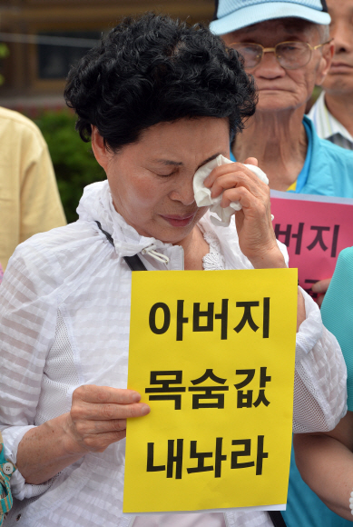 19일 오전 종로구 효자동 청운주민센터 앞에서 열린 일제하 국외 강제 동원군인군속 희생자 유족 협의회 청와대 규탄 대회에 참가한 희생자 유가족이 보상을 요구하는 피켓을 들고 울고 있다.  박지환 popocar@seoul.co.kr