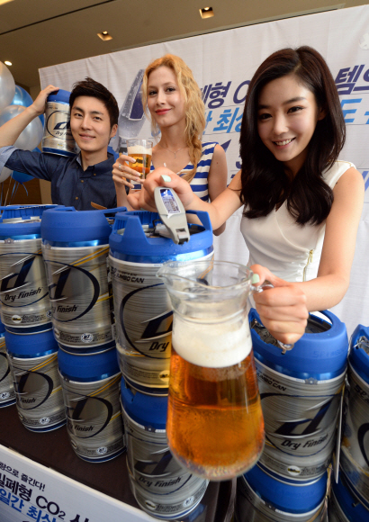 26일 서울 중구 소공로 플라자호텔에서 하이트진로 도우미들이 맥주 소비가 많은 여름철을 겨냥해 출시된 맥주 브랜드 d의 대용량(5ℓ) 점보캔에서 맥주를 따라 보이고 있다. 밀폐형 이산화탄소(CO2) 시스템을 갖춘 휴대용 전용 용기에 330㎖ 15병에 달하는 맥주가 담겨 있어 가족 나들이나 홈파티용으로 적합하다. 정연호 기자 tpgod@seoul.co.kr
