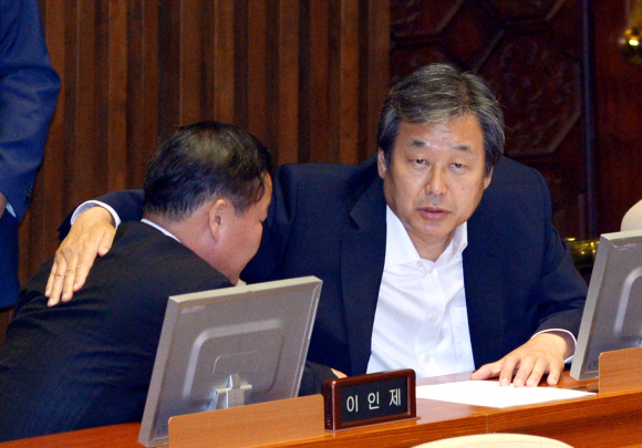 김무성(오른쪽) 새누리당 의원이 고개를 푹 숙인 채 앉아 있는 김재원 당 전략기획본부장의 등을 다독이고 있다. 이호정 기자 hojeong@seoul.co.kr