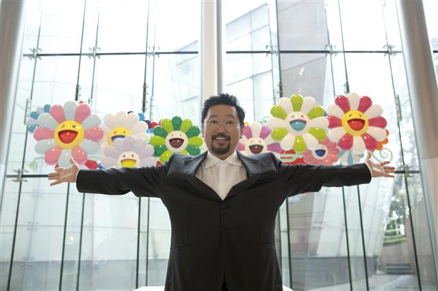 무라카미 다카시가 자신의 ‘슈퍼플랫’ 이론을 적용한 작품 ‘슈퍼플랫 플라워’ 앞에 서 있다. 일본 회화의 전통 주제인 꽃을 활용했다. 삼성미술관 플라토 제공