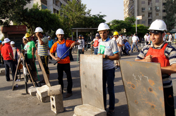 4일 오후(현지시간) 이집트 수도 카이로 나스르시티(Nasrcity) 주변 도로를 군인들이 장갑차를 동원해 막고 있다. 이곳에서 약 1km 떨어진 나스르시티 라바 광장에서는 수천명이 운집해 무함마드 무르시 이집트 대통령 지지 집회를 열었다. 군인과 무르시 집회 참가자 사이에는 장갑차와 철조망이 자리 잡고 있었고 일부 시위 참가자는 철조망 앞에서 무르시 사진을 들어 보였다.  연합뉴스