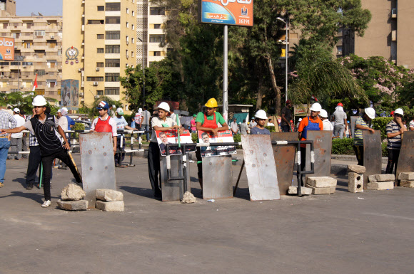 4일 오후(현지시간) 이집트 수도 카이로 나스르시티(Nasrcity) 주변 도로를 군인들이 장갑차를 동원해 막고 있다. 이곳에서 약 1km 떨어진 나스르시티 라바 광장에서는 수천명이 운집해 무함마드 무르시 이집트 대통령 지지 집회를 열었다. 군인과 무르시 집회 참가자 사이에는 장갑차와 철조망이 자리 잡고 있었고 일부 시위 참가자는 철조망 앞에서 무르시 사진을 들어 보였다.  연합뉴스