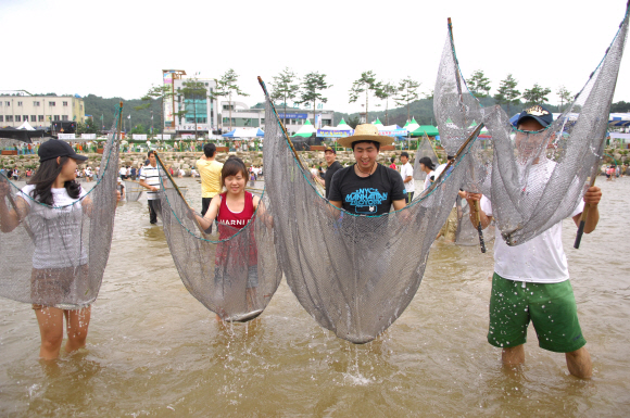 봉화은어축제 가운데 은어잡기 행사 참가자들이 은어가 잡힌 반두를 들어보이고 있다.