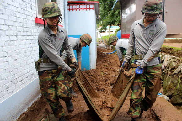 육군 제1야전군 장병들, 수해복구 ‘구슬땀’ 육군 제1야전군 사령부가 최근 중부지방을 강타한 집중호우로 수해가 발생한 강원지역의 복구 지원 활동에 적극 나섰다.1군사령부는 17일 수해지역인 춘천과 홍천, 횡성, 인제 지역에 500여명의 병력을 긴급 투입해 대민 지원활동을 벌였다. 사진은 홍천지역에서 11사단 장병들이 복구작업을 벌이는 모습 연합뉴스