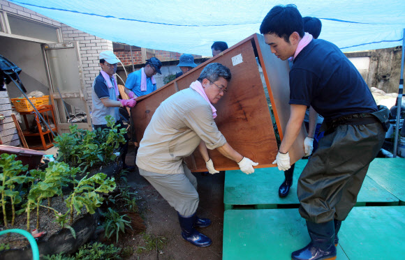 춘천 침수 피해지 자원봉사 발길 17일 오전 한국은행 강원본부 본부장을 비롯한 직원들이 집중호우로 침수 피해를 입은 강원 춘천시 효자동 일대에서 물에 젖은 가구를 밖으로 꺼내오고 있다.   연합뉴스