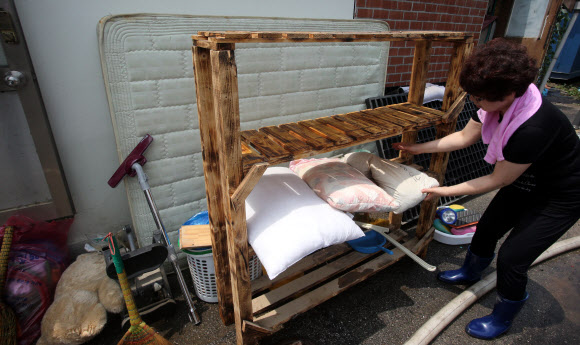 햇볕에 말리는 춘천 침수 피해지  17일 오전 자원봉사자들이 집중호우로 침수 피해를 입은 강원 춘천시 효자동 일대에서 물에 젖은 침구류를 햇볕에 말리고 있다.  연합뉴스