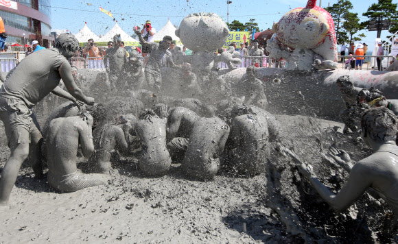 ‘제16회 보령머드축제’가 19일 충남 보령시 신흑동 대천해수욕장에서 개막식을 하고 10일간의 일정에 들어갔다. 축제장을 찾은 관광객들이 머드를 온몸에 흠뻑 바르고 즐거운 시간을 보내고 있다. 연합뉴스