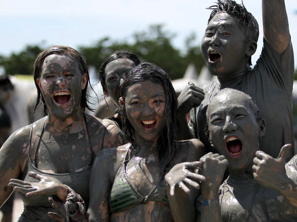 보령머드축제가 19일 충남 보령 대천해수욕장에서 개막했다. 축제장을 찾은 관광객들이 온몸에 머드를 흠뻑 묻히고 축제를 즐기고 있다. 연합뉴스