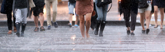 주말동안 잠시 소강상태를 보였던 장맛비가 다시 시작된 22일 오전 서울 광화문 네거리를 지나는 출근길 시민들이 발걸음을 재촉하고 있다.  연합뉴스