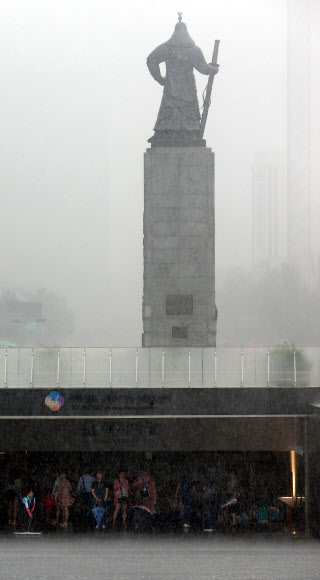 주말동안 잠시 소강상태를 보였던 장맛비가 다시 시작된 22일 오전 서울 광화문 광장 지하 해치마당에서 시민들이 장대비를 피하고 있다.   연합뉴스