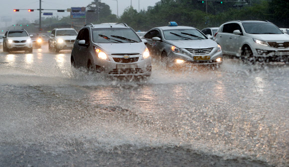 서울을 비롯한 중부지방에 많은 양의 비가 내린 22일 오전 서울 여의도 도로에서 차량들이 빗물을 헤치며 운행하고 있다 연합뉴스