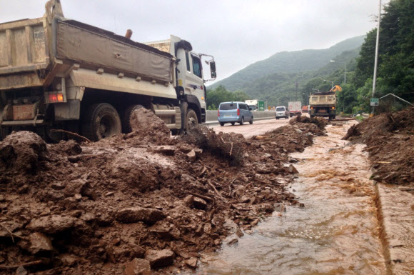 22일 오전 12시 30분께 경기도 이천시 중부고속도로 통영 방향 용면교 부근 332km 지점 야산에서 쓸려 내려온 토석류 300㎥를 한국도로공사가 1차선을 막고 복구작업 중이다.  연합뉴스