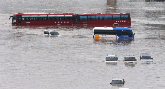 서울 송파구에 누적 강수량 145.5㎜의 집중호우가 내린 22일 오전 탄천에 불어난 물이 인근의 잠실 탄천 주차장을 덮쳐 고속버스를 비롯한 차량 40여대가 물에 잠겼다. 손형준 기자 boltagoo@seoul.co.kr