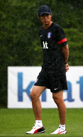 2013 동아시아연맹(EAFF) 축구선수권대회(동아시안컵) 중국과의 경기를 이틀 앞둔 22일 오후 경기도 파주 대표팀트레이닝센터(NFC)에서 홍명보 국가대표팀 감독이 비를 맞으며 잠시 생각에 잠겨 있다. <연합뉴스>