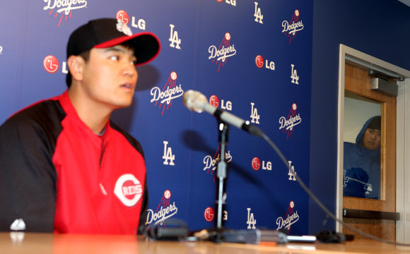 25일 오후(현지시간) 로스앤젤레스 다저스 스타디움에서 열린 신시내티 레즈와 로스앤젤레스 다저스의 경기에 앞서 열린 추신수의 기자회견에서 류현진이 회견장 뒤 문에서 빼꼼이 얼굴을 내밀어 추신수의 회견을 보고 있다. 연합뉴스