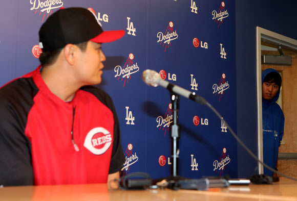 25일 오후(현지시간) 로스앤젤레스 다저스 스타디움에서 열린 신시내티 레즈와 로스앤젤레스 다저스의 경기에 앞서 열린 추신수의 기자회견에서 류현진이 회견장 뒤 문에서 빼꼼이 얼굴을 내밀어 추신수의 회견을 보고 있다. 연합뉴스