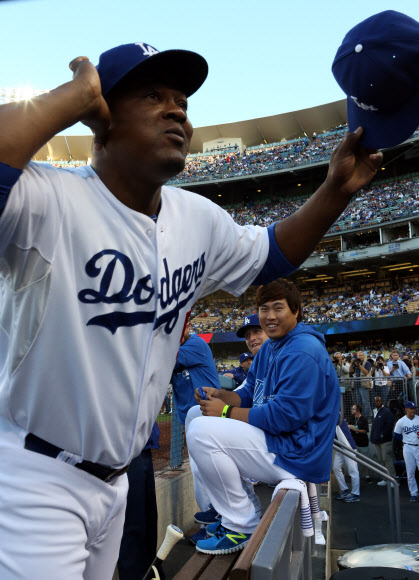 25일 오후(현지시간) 로스앤젤레스 다저스 스타디움에서 열린 신시내티 레즈와 로스앤젤레스 다저스의 경기에서 더그아웃에 대기중인 류현진이 절친 동료 유리베가 자신의 모자를 빼앗아 관중에게 주는 시늉을 하자 웃으며 쳐다보고 있다. 연합뉴스