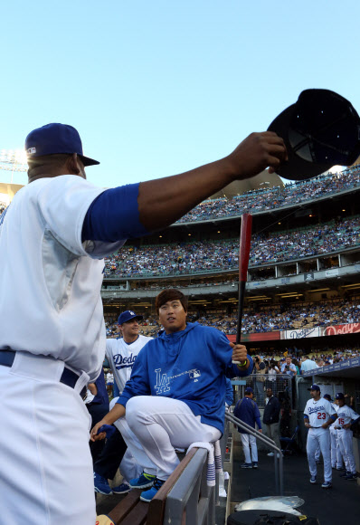 25일 오후(현지시간) 로스앤젤레스 다저스 스타디움에서 열린 신시내티 레즈와 로스앤젤레스 다저스의 경기에서 더그아웃에 대기중인 류현진이 절친 동료 유리베가 자신의 모자를 빼앗아 가자 방망이로 때리는 시늉을 하며 장난을 치고 있다. 연합뉴스