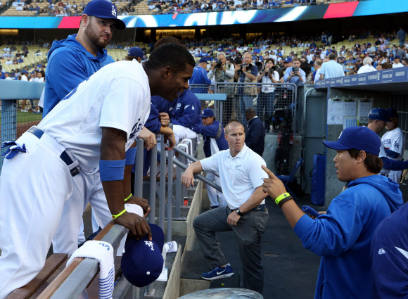 25일 오후(현지시간) 로스앤젤레스 다저스 스타디움에서 열린 신시내티 레즈와 로스앤젤레스 다저스의 경기에서 더그아웃에 대기중인 류현진이 절친 동료 푸이그와 이야기 나누고 있다. 연합뉴스