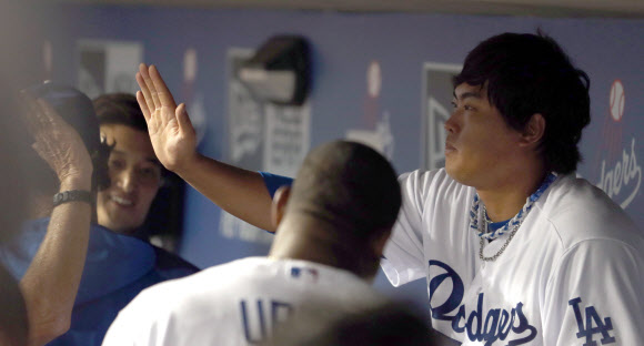 27일 오후(현지시간) LA다저스 스타디움에서 열린 LA다저스와 신시내티 레즈의 경기에서 다저스 선발투수 류현진이 7회초 수비를 마치고 더그아웃으로 들어와 동료들과 하이 파이브하고 있다. 연합뉴스