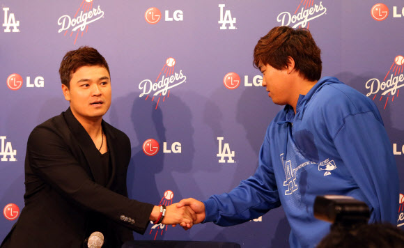 27일 오후(현지시간) LA다저스 스타디움에서 열린 LA다저스와 신시내티 레즈와의 경기를 마친뒤 류현진과 추신수가 기자회견장에서 만나 서로를 격려하며 악수하고 있다.  연합뉴스