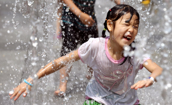 서울의 최고기온이 32도를 기록한 1일 오후 서울 광화문광장에서 한 아이가 물놀이를 하고 있다.  연합뉴스