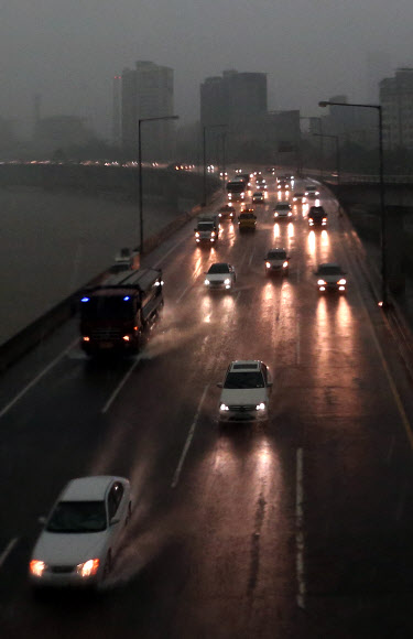 서울 지역에 폭우가 쏟아진 6일 오후 서울 마포구 서강대교 북단에서 바라본 강변북로를 오가는 차들이 라이트를 켠 채 운행하고 있다. 연합뉴스