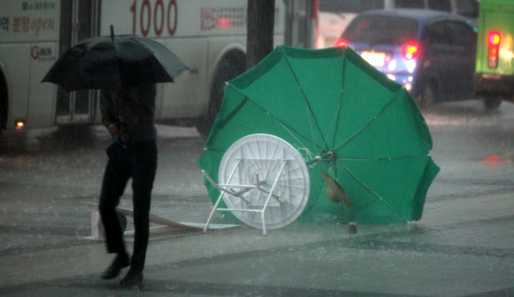 6일 오후 폭우가 내리고 있는 광화문 거리를 한 시민이 걸어가고 있다.  연합뉴스