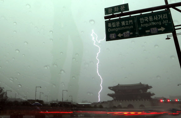 천둥 번개를 동반한 국지성 폭우가 내린 6일 낮 서울 광화문 인근에 폭우와 함께 번개가 내리치고 있다.  연합뉴스