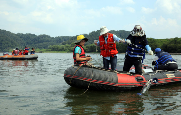 6일 오후 낙동강 칠서취수장 인근 강에서 낙동강물환경연구소 연구원들이 DO, PH,  클로로필 농도, 적조류 개체수 등을 측정을 위해 취수를 하고 있다.  연합뉴스
