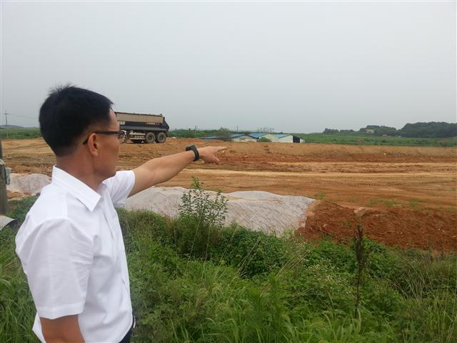 한 평택시 공무원이 공사 중인 현장을 가리키는 모습.<br>