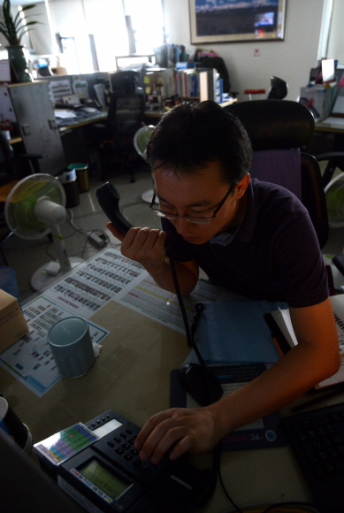 12일 공공기관의 냉방기 가동을 전면 중단한 가운데 정부서울청사 안전행정부 한 사무실에서 직원들이 불을 끈 채 업무를 보고 있다. 박지환 popocar@seoul.co.kr