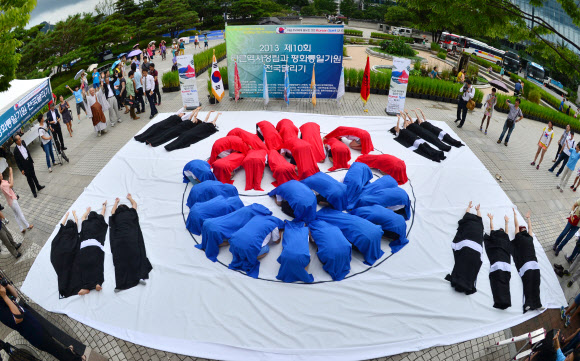 15일 서울 광화문 열린시민광장에서 세계국학원청년단 주관으로 열린 ‘광복 68주년 8.15 태극기 플래시몹 행사’에서 참가자들이 멋진 퍼포먼스를 선보이고 있다. 세계국학원청년단은 이날 “광복절 태극기를 들어 대한민국의 얼을 깨워주세요!”라는 주제로 전국적으로 태극기플래쉬몹 행사를 열었다.  연합뉴스