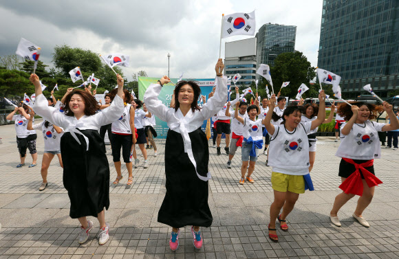 15일 서울 광화문 열린시민광장에서 세계국학원청년단 주관으로 열린 ‘광복 68주년 8.15 태극기 플래시몹 행사’에서 참가자들이 가수 싸이의 ‘젠틀맨’ 노래에 맞쳐 멋진 율동을 선보이고 있다. 세계국학원청년단은 이날 “광복절 태극기를 들어 대한민국의 얼을 깨워주세요!”라는 주제로 전국적으로 태극기플래쉬몹 행사를 열었다.  연합뉴스