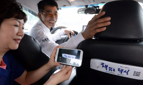 서울 송파구의 ‘책 읽는 택시’를 탄 승객이 스마트폰으로 EBS FM(104.5㎒) ‘책 읽어 주는 라디오’를 듣고 있다.