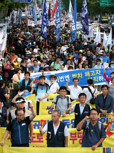 24일 오후 쌍용차 범국민 대회 참가자들이 서울 중구 남대문로에서 쌍용차 해고자 복직과 국정조사 실시 등을 촉구하며 거리행진을 하고 있다. 연합뉴스