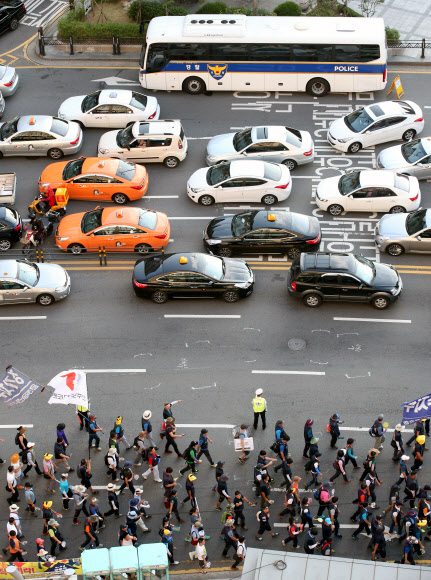 24일 오후 쌍용차 범국민 대회 참가자들이 서울 중구 남대문로에서 쌍용차 해고자 복직과 국정조사 실시 등을 촉구하며 거리행진을 하고 있다. 연합뉴스