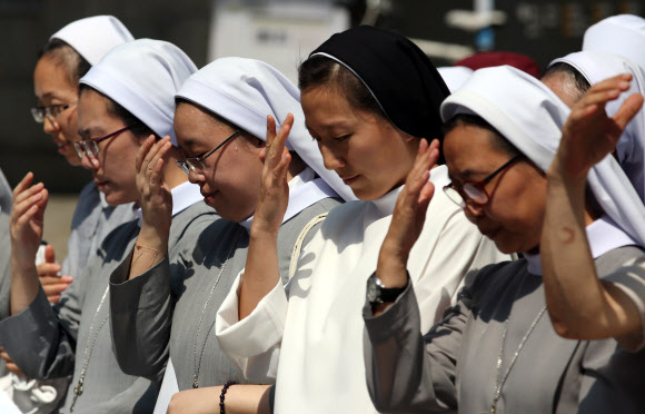 천주교 수녀들이 26일 오전 서울 중구 정동 덕수궁 대한문 앞에서 쌍용자동차 사태 해결을 염원하는 기자회견을 시작하며 성호를 긋고 있다. 연합뉴스