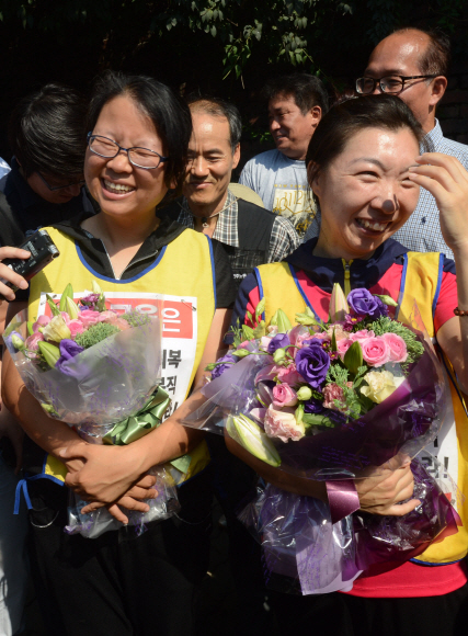 2076일간의 투쟁을 마치고 노사가 합의에 이른 26일 오후 서울 재능교육 앞 혜화성당에서 농성중이던 노동자가 꽃다발을 들고 성당을 내려오고 있다.  박지환 popocar@seoul.co.kr