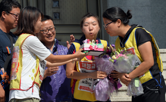 26일 오후 서울 재능교육 앞 혜화성당에서 농성중이던 노동자가 농성을 풀고 내려와 케이크에 촛불을 끄고 있다.  박지환 popocar@seoul.co.kr