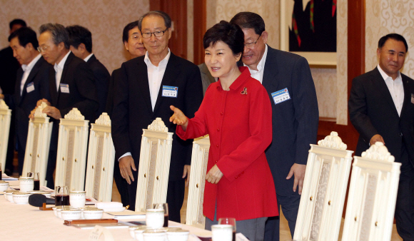 박근혜 대통령이 29일 중견기업 대표들을 청와대로 초청해 오찬 간담회를 갖기에 앞서 참석자들을 자리로 직접 안내하고 있다. 박 대통령은 스스로 “투자활성화복”이라고 지칭한 빨간색 재킷을 입고 나와 눈길을 끌었다. 청와대사진기자단