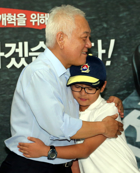 김한길 민주당 대표가 3일 밤 서울광장 천막당사로 격려방문을 온 아들 무진군과 포옹하고 있다. 연합뉴스