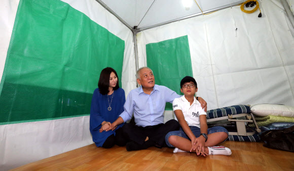 김한길 민주당 대표의 부인 최명길씨(왼쪽)와 아들 무진군(오른쪽)이 3일 밤 시청 앞 김대표의 농성장을 방문해 김대표를 격려하고 있다. 연합뉴스