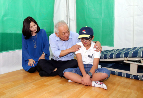 김한길 민주당 대표의 부인 최명길씨(왼쪽)와 아들 무진군(오른쪽)이 3일 밤 시청 앞 김대표의 농성장을 방문해 김대표를 격려하고 있다. 연합뉴스