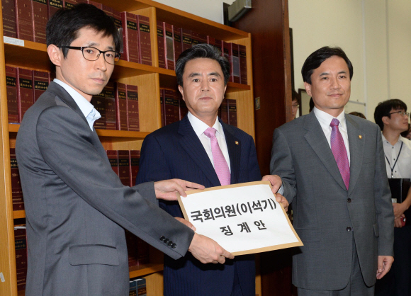 새누리당 김태흠(가운데)·김진태(오른쪽) 의원이 6일 국회 사무처 의안과 관계자에게 통합진보당 이석기 의원을 의원직에서 제명하는 내용을 담은 징계안을 제출하고 있다. 이호정 기자 hojeong@seoul.co.kr