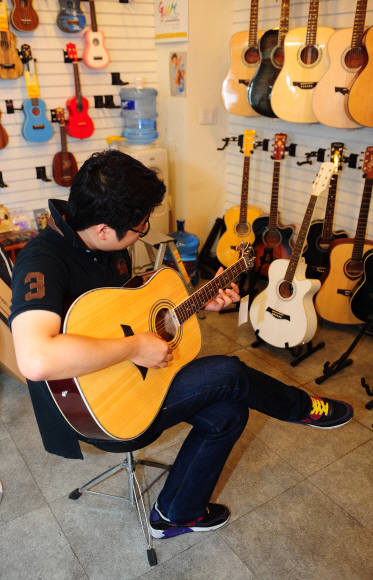 5일 서울 종로구 낙원상가 내 한 기타 전문 매장에서 기자가 직접 가장 싼 어쿠스틱 기타를 연주하고 있다.