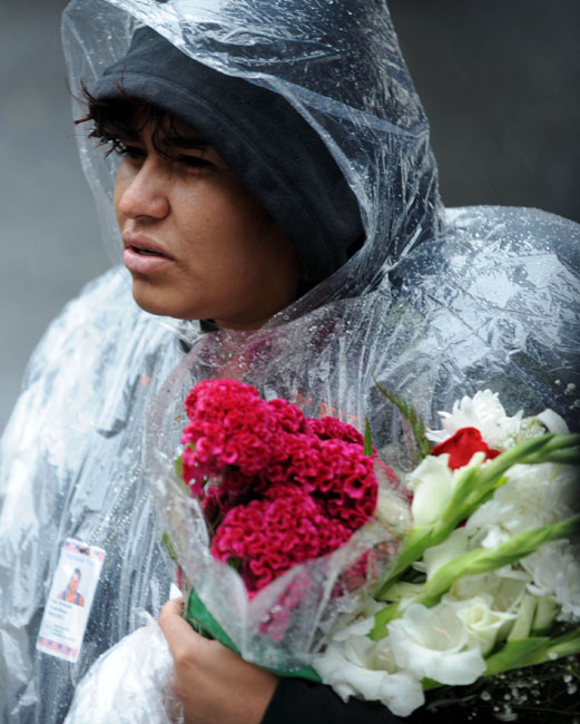 11일(현지시간) 미국 뉴욕의 그라운드 제로에서 911테러 발발 8주기 추모행사가 열린 가운데 한 여성이 우의를 입고 꽃다발을 든 채 행사에 참가하고 있다. 【뉴욕(미 뉴욕주)=신화/뉴시스】